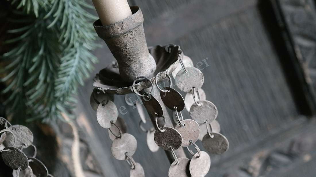 Muntjeskandelaar in oud bruin met hangende metalen muntjes langs de kaars
