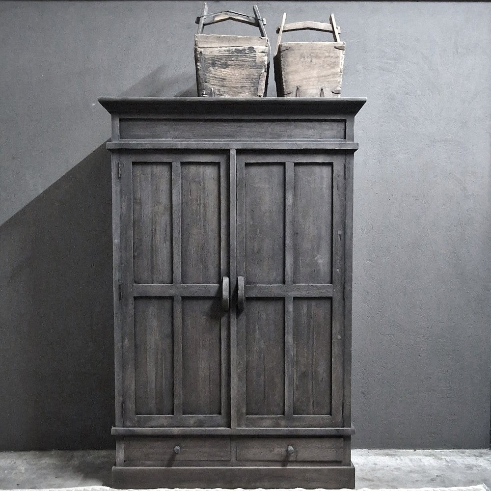 Kast Nick- Luksa, donker houten kledingkast met paneeldeuren en twee laden onderaan, twee houten manden bovenop.