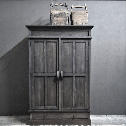 Kast Nick- Luksa, donker houten kledingkast met paneeldeuren en twee laden onderaan, twee houten manden bovenop.