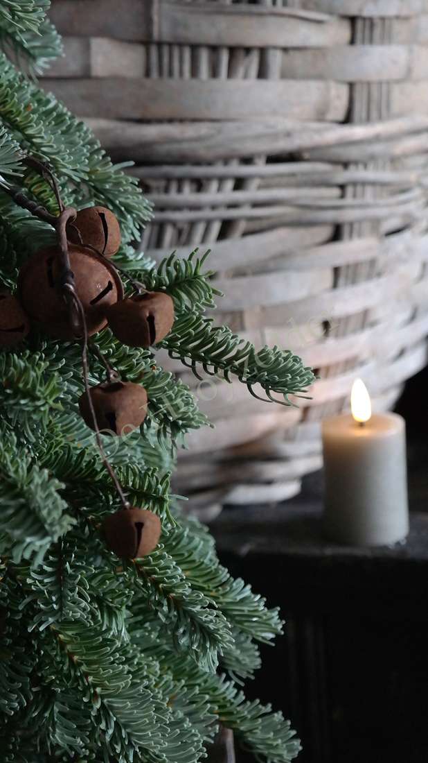 Nobilis kerstboom real touch tak met donkergroene naalden en bruine kegels, kaars op achtergrond