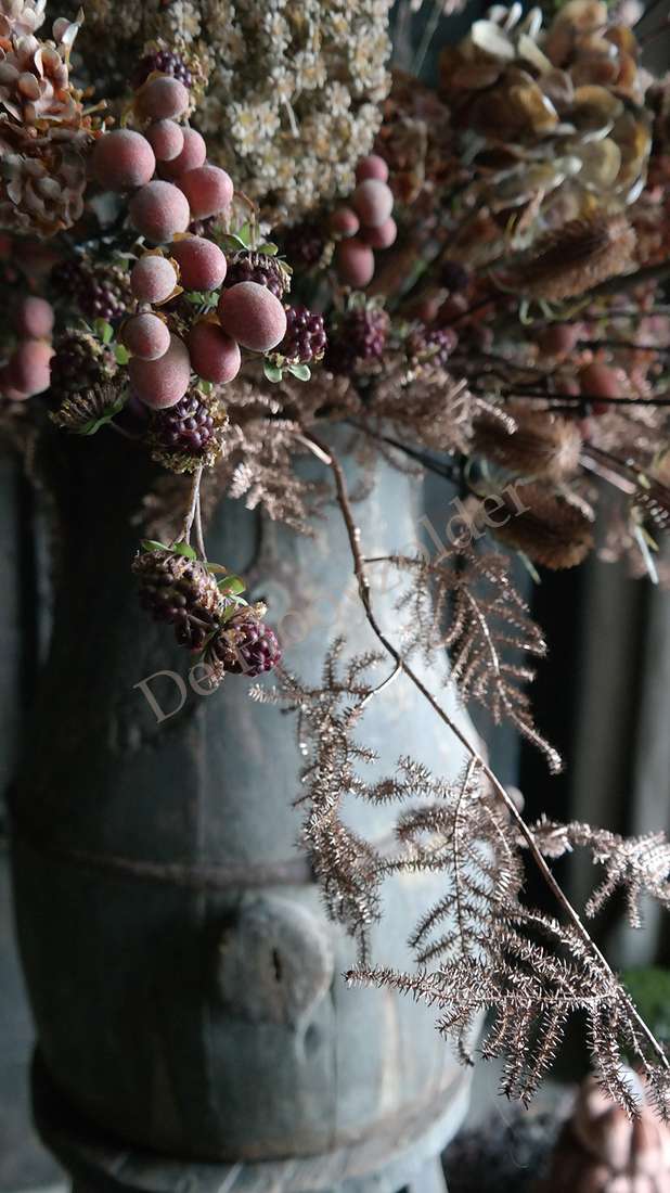 Asparagus tak wild namaak in koperkleur met roze bessen in een metalen pot