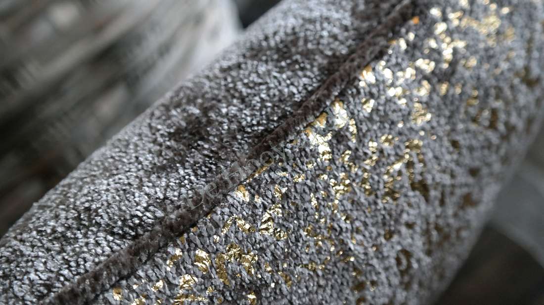 Kussen flow - bruin/goud, close-up van textiel met glanzende gouden accenten