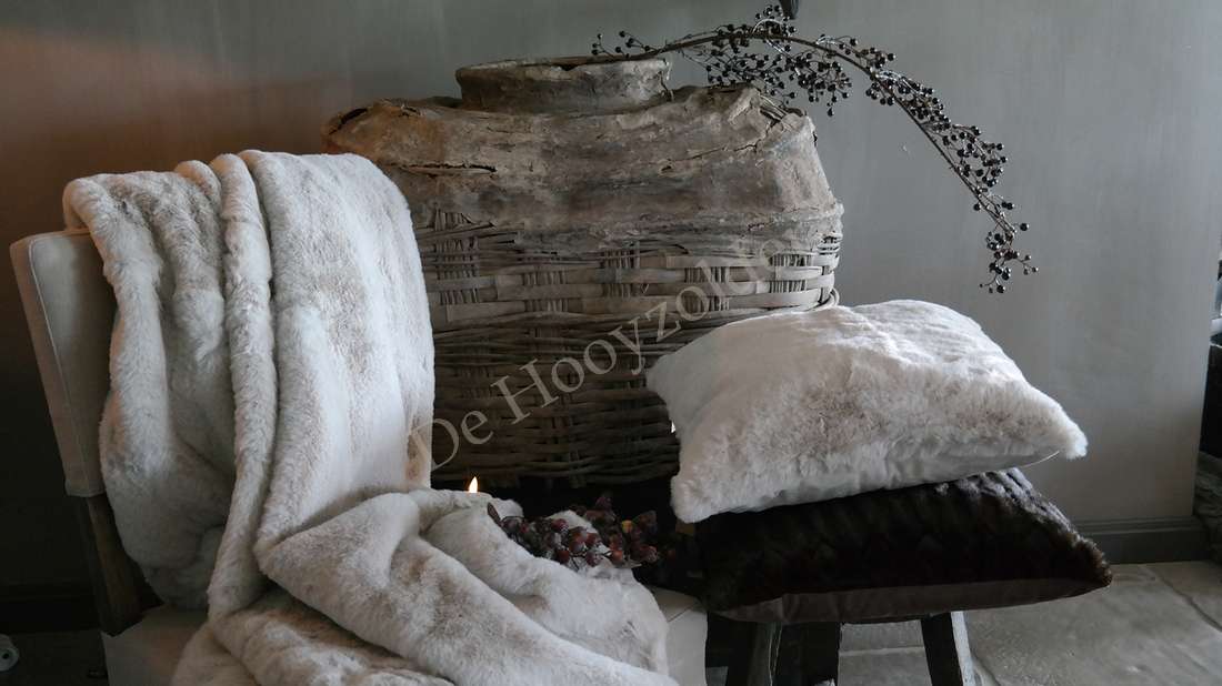 Kussen Zaya bont créme, crèmekleurig faux fur, merk De Hooyzolder, naast rieten mand.