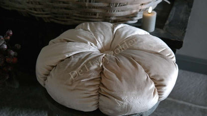 Kussen velvet rond beige van De Hooyzolder; zachte ronde vorm naast kaars op rustieke tafel.