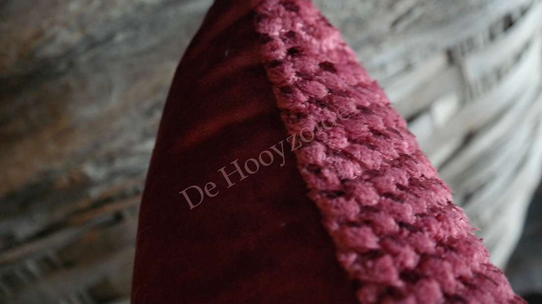 Kussen Rick fluffy in bordeaux met bouclé-achtige textuur; merk De Hooyzolder zichtbaar