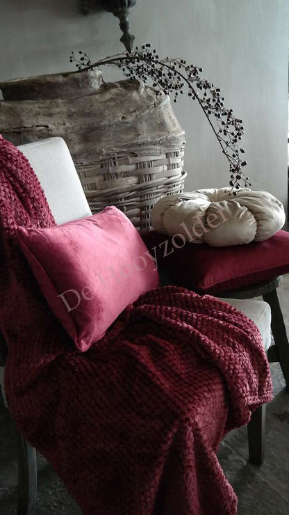 Plaid Rick fluffy - bordeaux van De Hooyzolder op stoel met twee kussens (roze en beige)