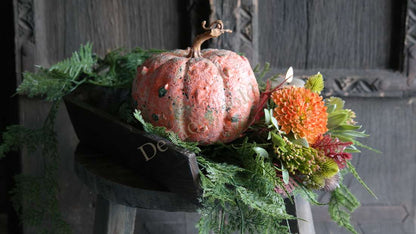 Graanschep van donkerbruin hout met De Hooyzolder-watermerk, op zwarte houten schaal met pompoen en bloemen