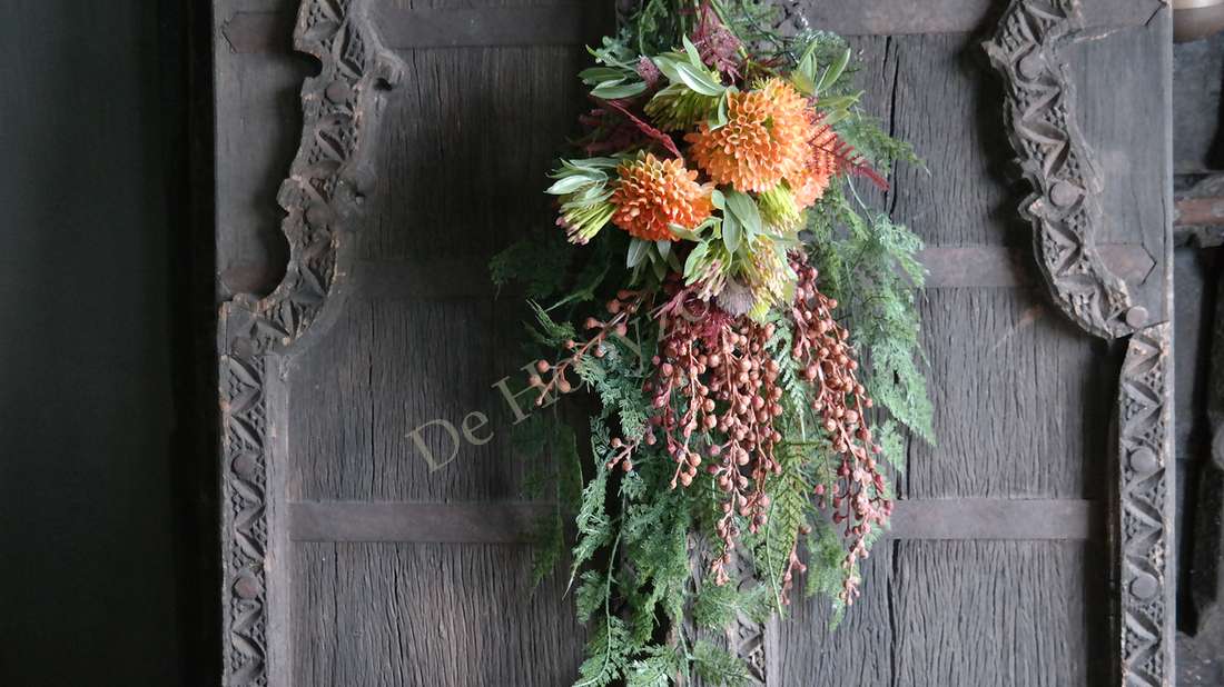 Hanger met groene namaak asparagustak, oranje bloemen en vallende takken, De Hooyzolder