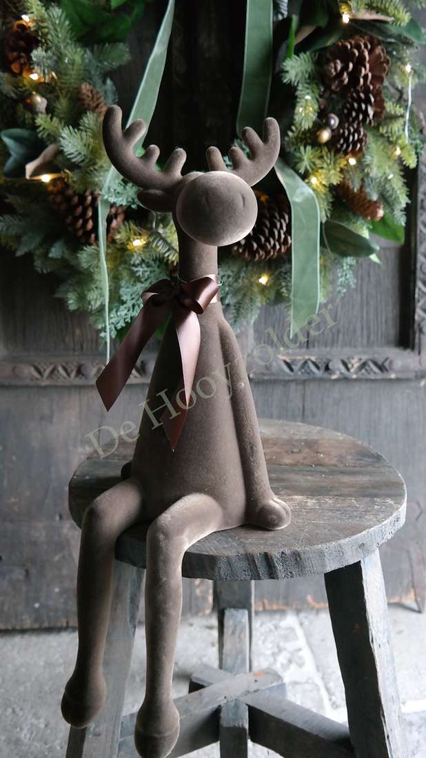 Rendier zittend velvet bruin met strik, op houten kruk, achtergrond kerstkrans met lampjes, De Hooyzolder