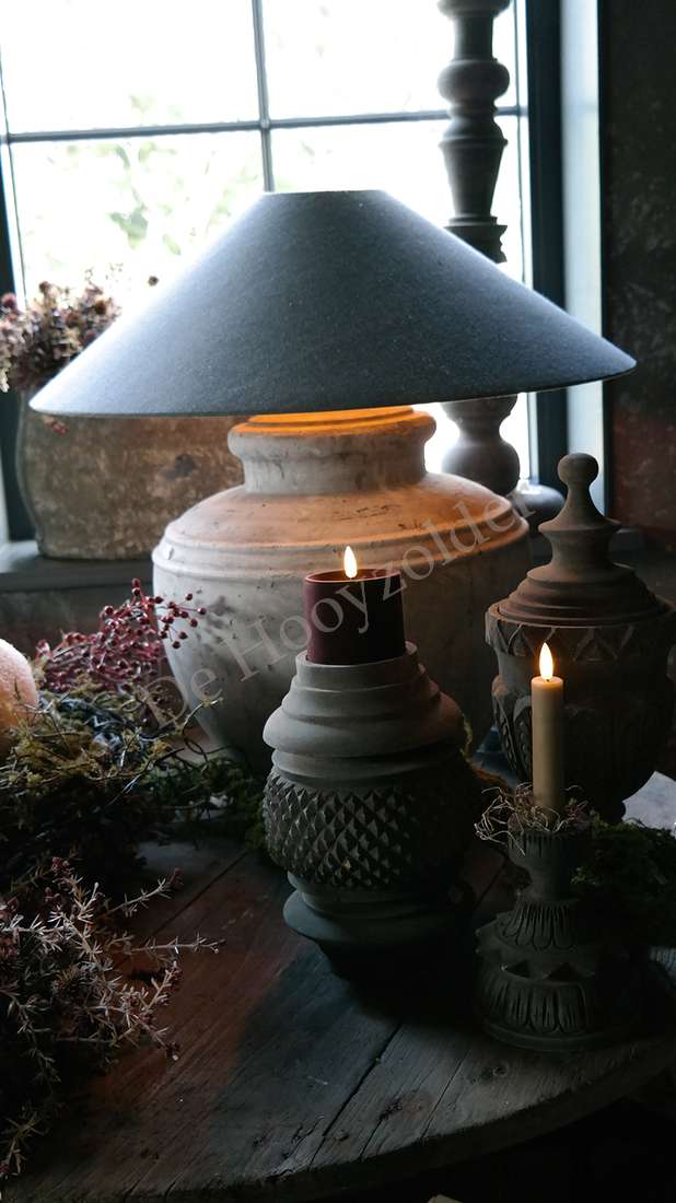 Luksa kandelaar Andi, donker metalen kandelaar met reliëftextuur op houten tafel, brandende kaarsen.