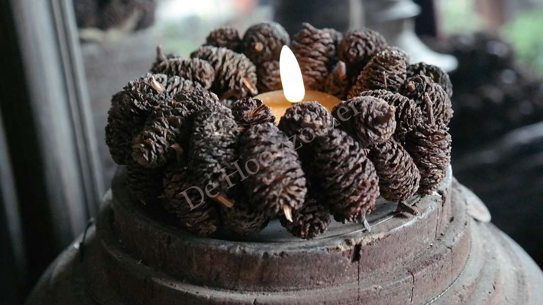 Dennenappelkransje 15 cm met brandende kaars, rondom donkerbruine dennenappels op een houten schijf (De Hooyzolder)