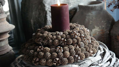 Herfstkrans, 25 cm, De Hooyzolder; ronde bruine krans met kleine bolletjes rondom een centrale donkerrode kaars.