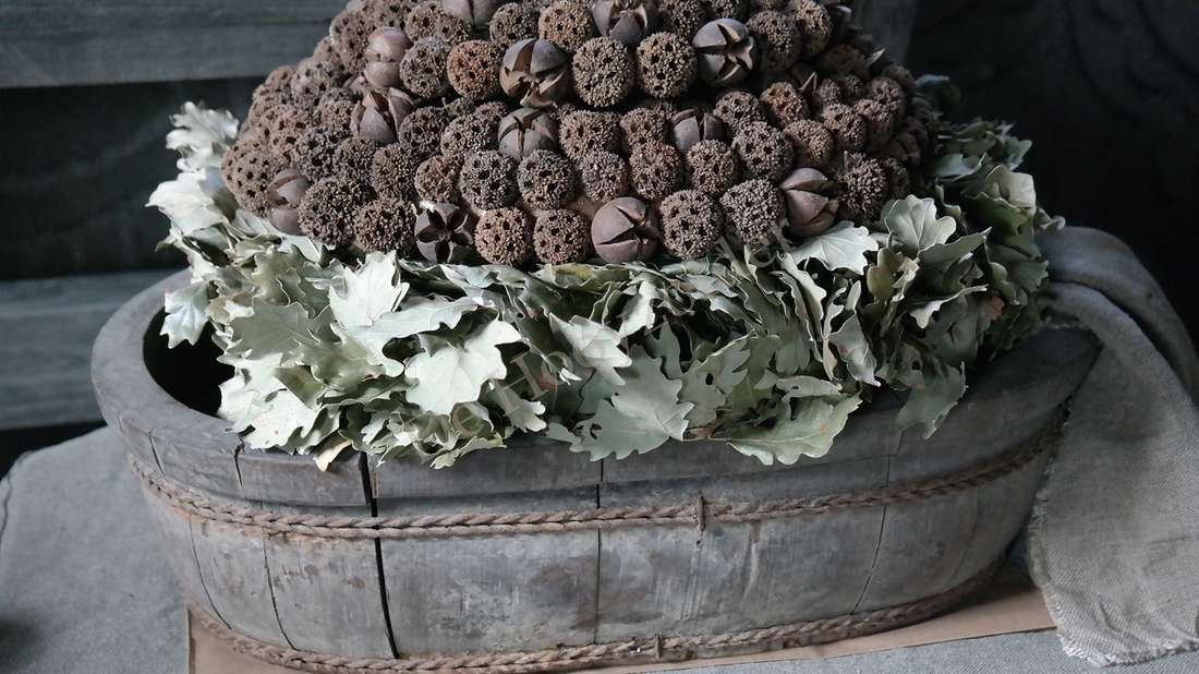 Herfst vrucht krans 25 cm van De Hooyzolder; gedroogde bruine bolvruchten met grijsgroene bladeren in een houten schaal