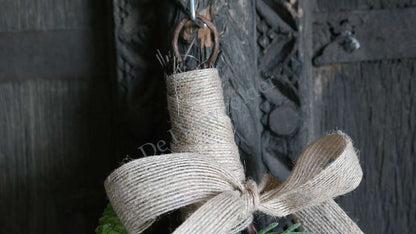 Toef Dennentak-bessen real touch S, De Hooyzolder; jute-strik rondom groen takdecor tegen donker houten achtergrond