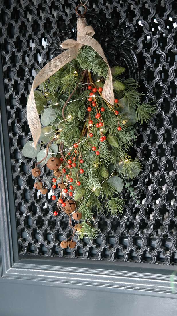 Toef dennentak-bessen hangdecoratie met groene takken, rode bessen, lampjes en jute strik