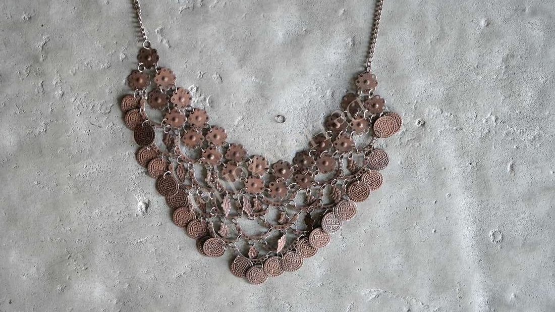 Sierketting met roestkleurige muntjes, drie lagen aan een metalen ketting