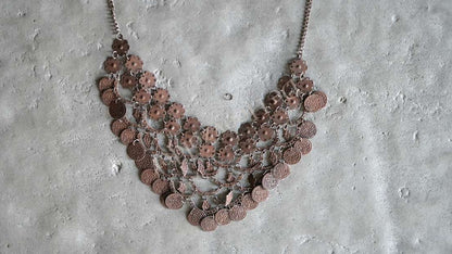 Sierketting met roestkleurige muntjes, drie lagen aan een metalen ketting
