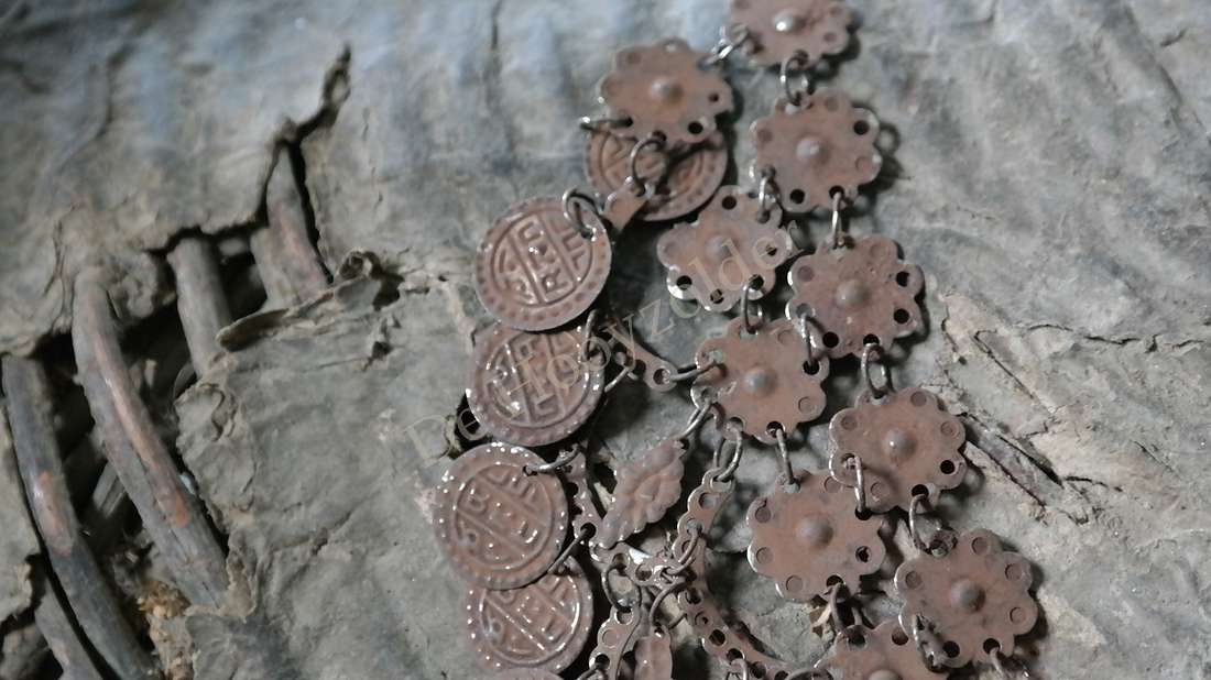 Sierketting van roestkleurige muntjes aan een metalen ketting