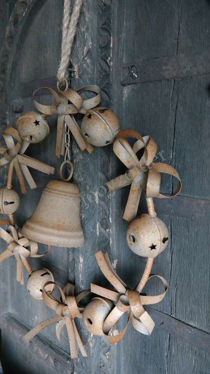 Krans bellen roest, 47 cm, roestkleurige metalen bellen met linten tegen een donkere houten achtergrond, De Hooyzolder