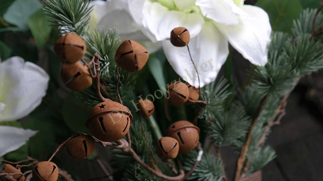 Belletjes tak roestkleurige decorballen aan dennennaalden, met witte bloem op achtergrond, De Hooyzolder.