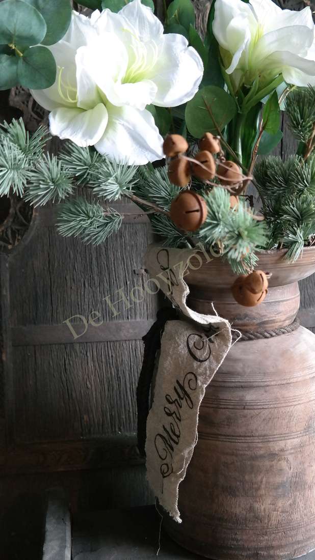 Boeket witte amaryllis van kunstplanten in een rustieke bruine vaas met eucalyptus en dennenaccenten, merk De Hooyzolder.