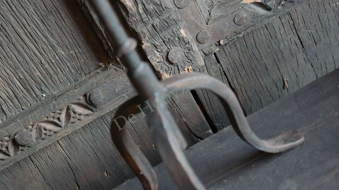 Drie-arm metalen kandelaar van De Hooyzolder tegen houten achtergrond