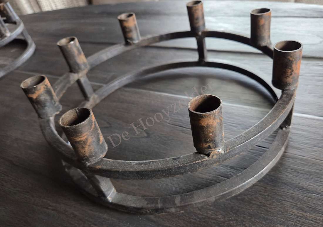 Metalen kaarsenhouder met acht kandelaren, roestkleurig rond frame; De Hooyzolder zichtbaar.